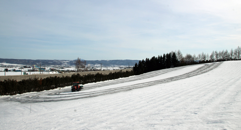 トラクターで丁寧に融雪剤を撒いていきます(彩りの畑)